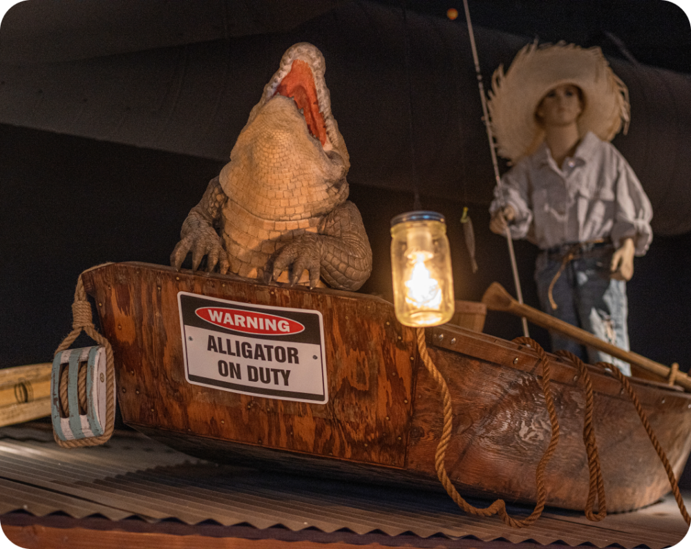 Man and an alligator sitting in a boat.